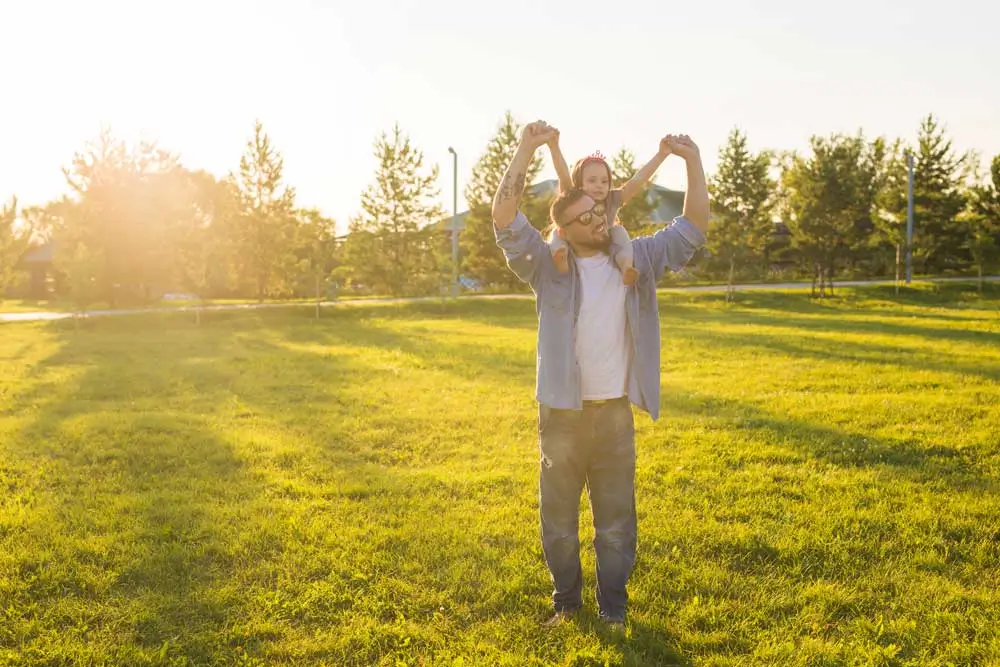 Father and daughter enjoy a sunny day on a healthy, vibrant lawn—showcasing the benefits of expert lawn care Rockville MD families rely on.